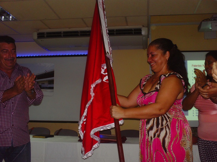 La MSc. Melek Campos recibe la bandera que acredita la condición de Vanguardia Nacional